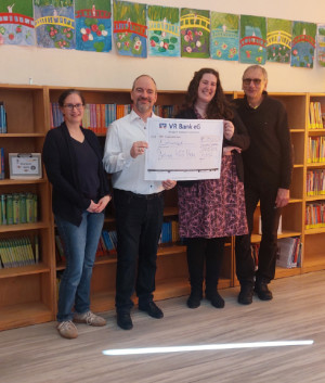 Kinder stehen vor den Regalen der Bücherei und überlegen wleche Bücher sie ausleihen möchten.